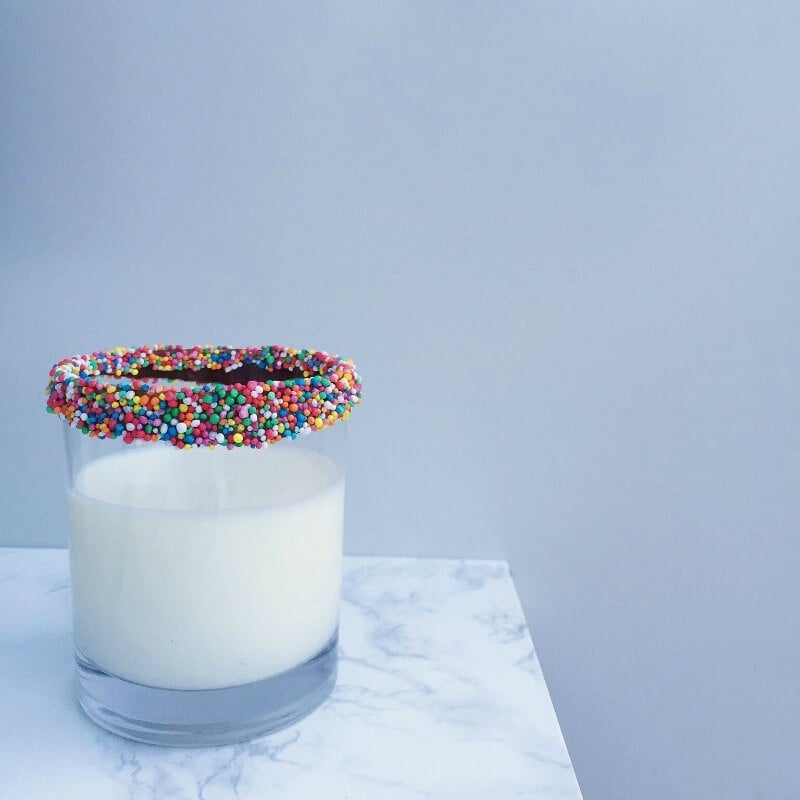 milk in glass with chocolate and sprinkles around the rim